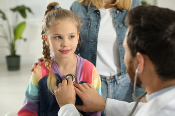 Mother and daughter having appointment with doctor. Pediatrician examining patient with stethoscope in clinic - Powered by Adobe
