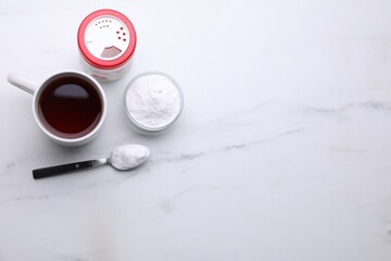 Sweet fructose powder and cup of tea on white marble table, flat lay. Space for text