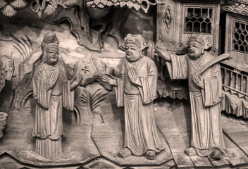 Close-up of wooden carving patterns of figures on ancient Chinese furniture