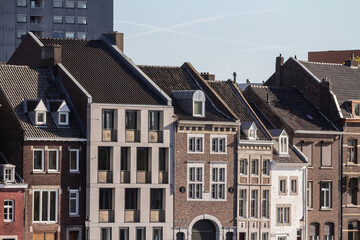Obraz premium Typical facades of dutch architecture in the city center of Maastricht, Netherlands, with residential buildings, facades of red brick and flats.