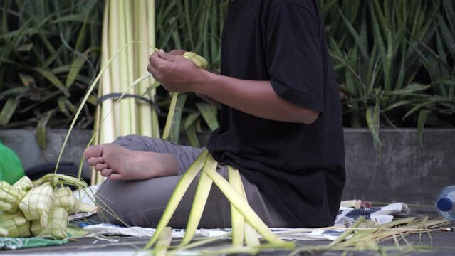 The process of making "Ketupat" nests on the sidewalk of Jalan Kotagede, Yogyakarta. Ketupat is a typical Eid food.