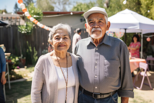 Portrait of Hispanic seniors at family gathering in backyard