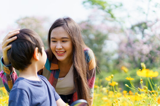 Happy Asian woman and son relaxing in the meadow field.