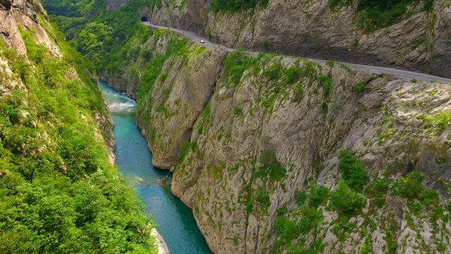 Aerial video of the stunning Moracha River canyon in Montenegro. Soar above the magnificent natural scenery, capturing stunning aerial views of the towering cliffs, crystal-clear river, and lush