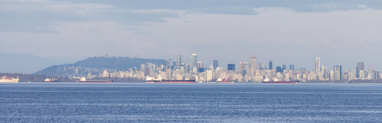 Fototapeta premium Downtown Vancouver City Skyline on the West Coast of Pacific Ocean. Cloudy Sunset. British Columbia, Canada.