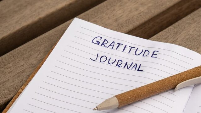 Zoom in out Writing Gratitude Journal on wooden bench. Today I am grateful for. Self discovery journal, self reflection creative writing, self growth personal development concept. Self care wellbeing