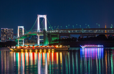 東京お台場から眺めるレインボーブリッジと屋形船の夜景