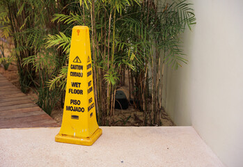 A yellow wet floor sign is a symbol of caution and warning, indicating a slippery and potentially hazardous area. It represents safety, prevention, and the need for attention and alertness in public 