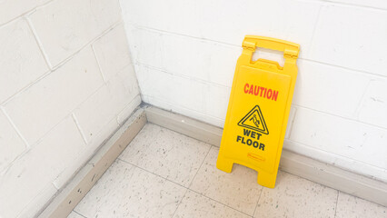 A yellow wet floor sign is a symbol of caution and warning, indicating a slippery and potentially hazardous area. It represents safety, prevention, and the need for attention and alertness in public 