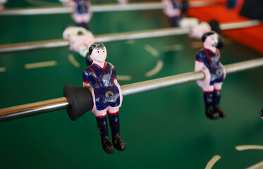 A foosball table is a recreational game symbolizing entertainment, skill, and socializing. It represents teamwork, competition, and the joy of play, and is often associated with bar and culture