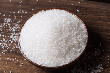 Bowls are filled with sugar on a wooden background