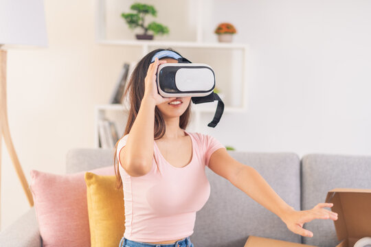 Concentrated young woman wearing virtual reality glasses