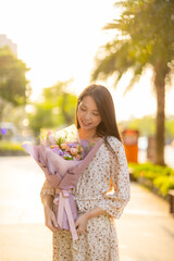 Woman hold with bouquet of flower under sunset time