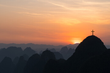 Obraz premium The crucifixion of the crucifixion of jesus christ on the cliffs and mountains. Sunset light. Selective focus.