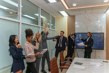 Group of businessmen and businesswomen cheers to celebrate their latest successful deal in a office meeting room. A team of sales person celebrate new high sales report.