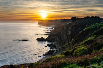 Panoramic view of the marine coast with an idyllic sunset over the horizon of the sea, Asturias, Spain.
