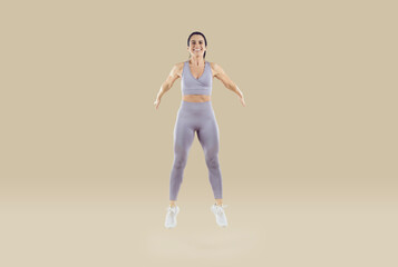 Fototapeta na wymiar Balance and endurance. Happy strong athletic woman with muscular body trains performing high jumps isolated on beige background. Healthy lifestyle concept. Full length. Banner.