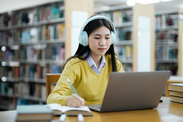 Student studying at library with laptop.