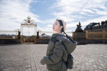 Woman posing at the Palace of Versailles outdoor in Paris, France.