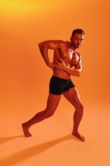 Fototapeta na wymiar Man bodybuilder boxer muscle workout with naked torso with abs posing in studio. Advertising, sports, active lifestyle, colored yellow light, competition, challenge concept. 
