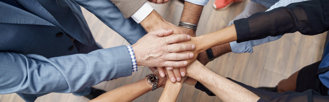Top view of group coworkers stacked hands together as concept of corporate unity