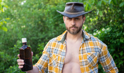 cowboy man with whiskey. cowboy man with whiskey bottle. cowboy man with whiskey