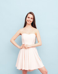 Portrait of young winsome woman in romantic attire pretty smiling on blue background. Slim female in pure pink dress posing in studio. Cheerful model. Isolated. Long hair