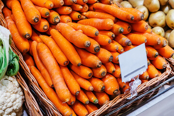 Lots of carrots on the counter in the store. Trade in fresh vegetables in the trading network and in the market. Close up