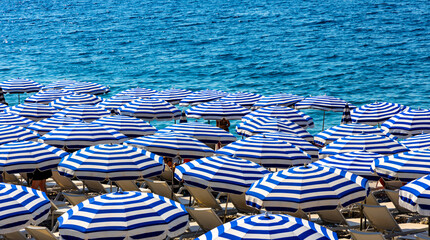 Summer beach umbrellas along Promenade des Anglais boulevard along Nice Mediterranean Sea shore on French Riviera Azure Coast in France