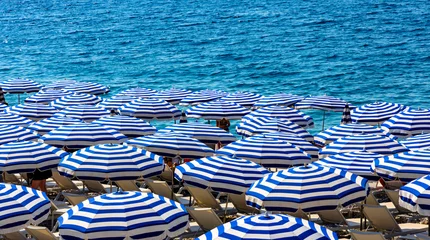 Foto op Plexiglas Nice Summer beach umbrellas along Promenade des Anglais boulevard along Nice Mediterranean Sea shore on French Riviera Azure Coast in France