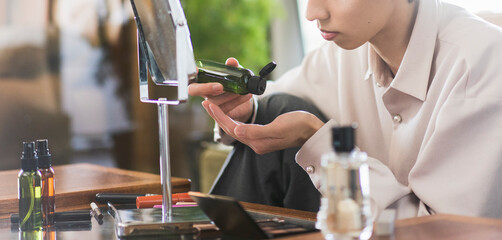 自宅リビングでスキンケアをしている若いアジア人男性/メンズビューティー