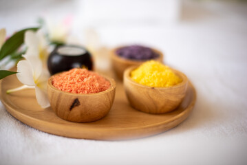 The white bed was covered with a bowl of array of different spa salt ingredientsin close up shot.