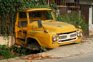 Tailgate of abandoned Vintage yellow truck parked in a field - obrazy, fototapety, plakaty