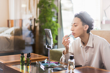 メイクをしているZ世代日本人男性ポートレート/リップを塗っている/メンズビューティー