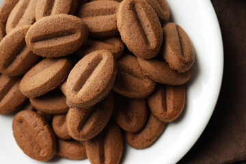 Concept of tasty snack for hot drink - cookies in the shape of coffee seeds
