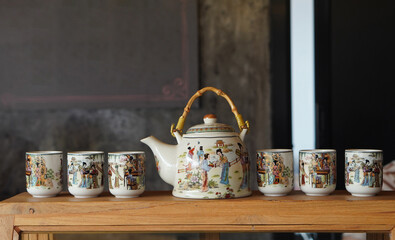 side view one ceramic kettle and six ceramic cups on glass and wood cabinet, object, decor, kitchen, copy space