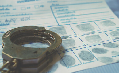 Police handcuff on fingerprint crime page file.Crime and violence concept.	