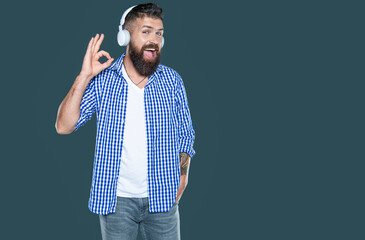 happy bearded man listen to music in headphones. ok