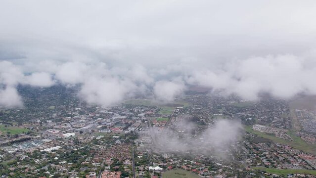 Drone flying over clouds and suburb.  Slow moving clouds on a cloudy day