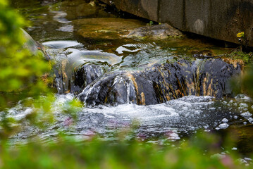 Closeup of flowing water over rocks in a garden water system