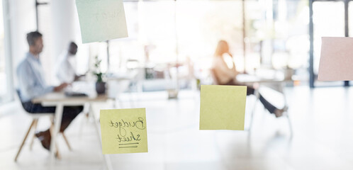 Sticky note, blurred background and business people sitting in an office for budget planning or strategy. Memo, glass and flare with a professional employee group at work in a corporate workplace