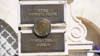 Nikola Tesla's face portrait on a metal plate at the entrance of Nikola Tesla Museum. Belgrade, Serbia - March 31, 2023.