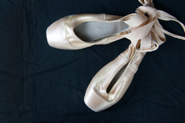 Pointe shoes on a black background top view