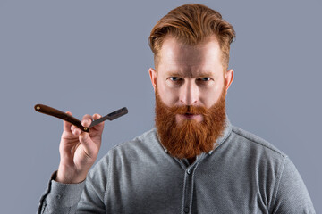 man holding barber blade for shaving. man shaving with barber blade isolated on grey background.