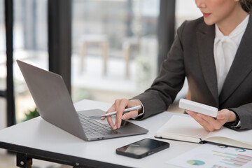 ฺAsia Businesswoman sitting and working using laptop to chat with customers online in office