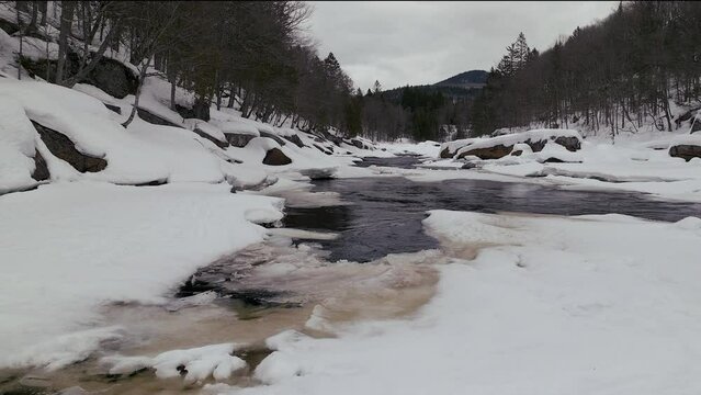 Aerial scenic drone forward motion Canadian  wilderness mid winter near north Quebec Stoneham Ski Resort of frozen over Sautaurski River upstream