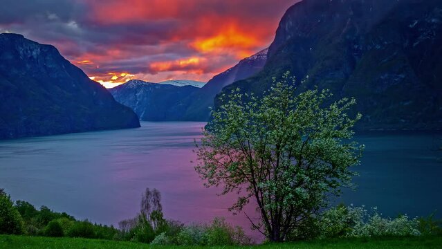 Timelapse shot of dark rain cloud movement over mountain slope in Norwegian Fjord in Flam, Norway during evening time.