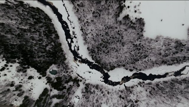 Aerial scenic cinematic drone straight down view pan Canadian  wilderness mid winter near north Quebec Stoneham Ski Resort of frozen over Sautaurski River
