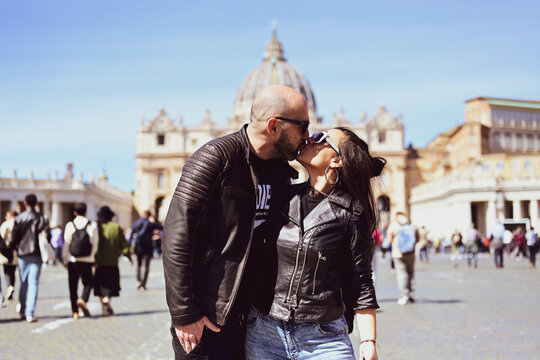 Happy smiling beautiful  Tourists  couple traveling at Rome, Italy, poses and making photos  in front of   Vatican City  at, Rome, Italy.Concept of Italian gastronomy and travel. Italian couple having