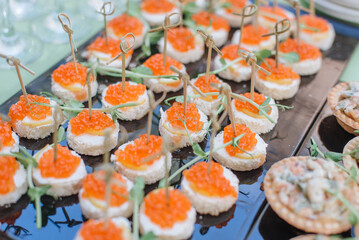 Bruschetta with cheese and red caviar on a plate, close-up